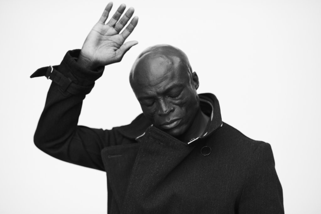 Seal raises his right hand and looks soulfully to the ground in a promo photo for summer concerts.