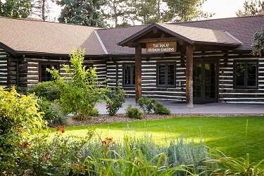 The front of a rustic, log cabin venue for wedding receptions, corporate events, and life celebrations in the Denver area.