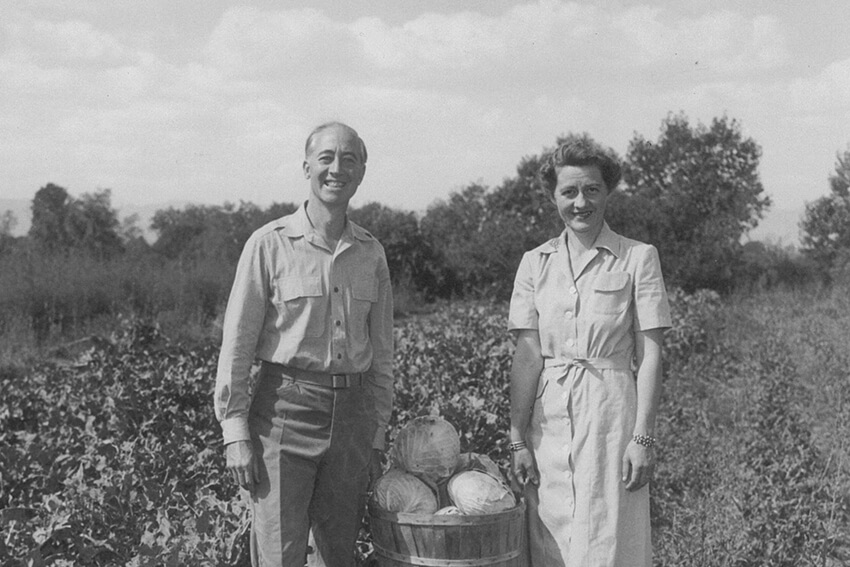 King and Evelyn Hudson hold a bushel of produce in the middle of a farm that later became a part of Hudson Gardens