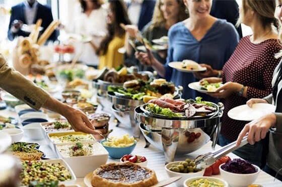 a lunch buffet served to a group of smiling guests at a private event venue