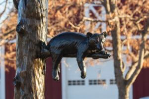 Bronze representation of two bear cubs climbing on a tree branch