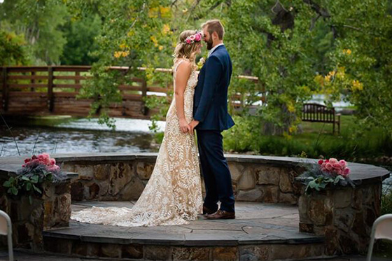A couple in wedding attire embracing outside at Hudson Gardens
