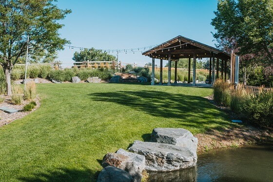 A lawn with a large wooden shelter in the distance
