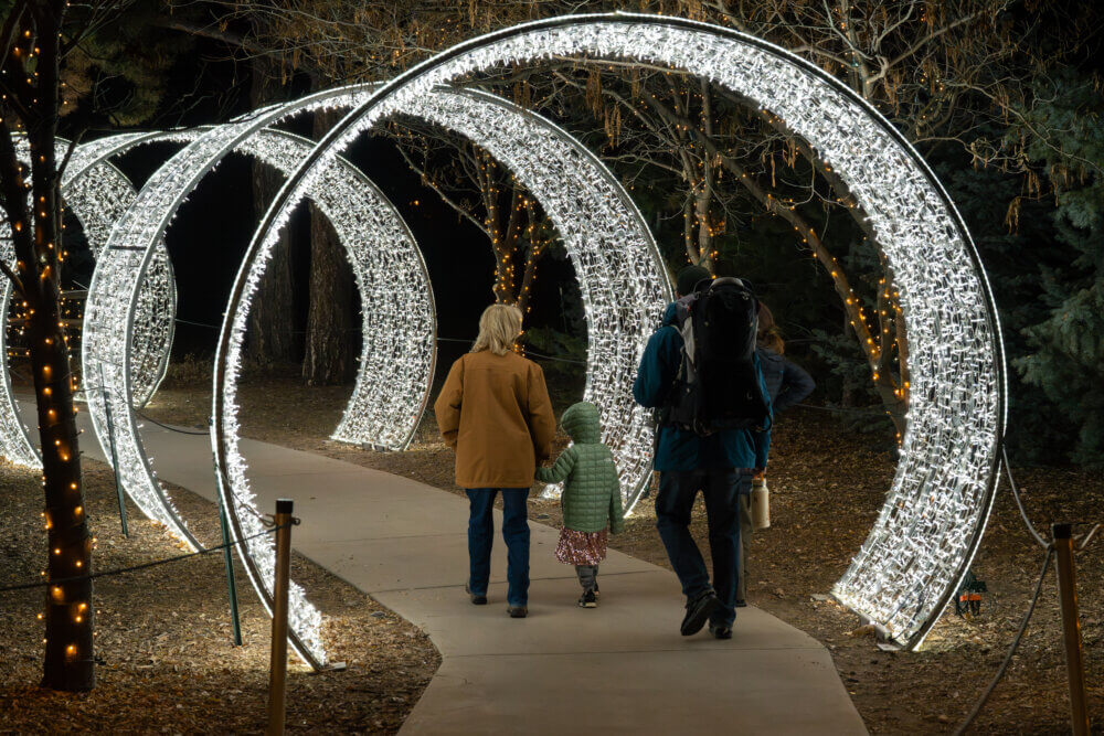 Family walking through circular light tunnels