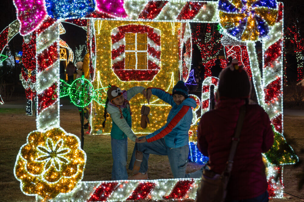 Kids posing in large-scale colorful lighted frame