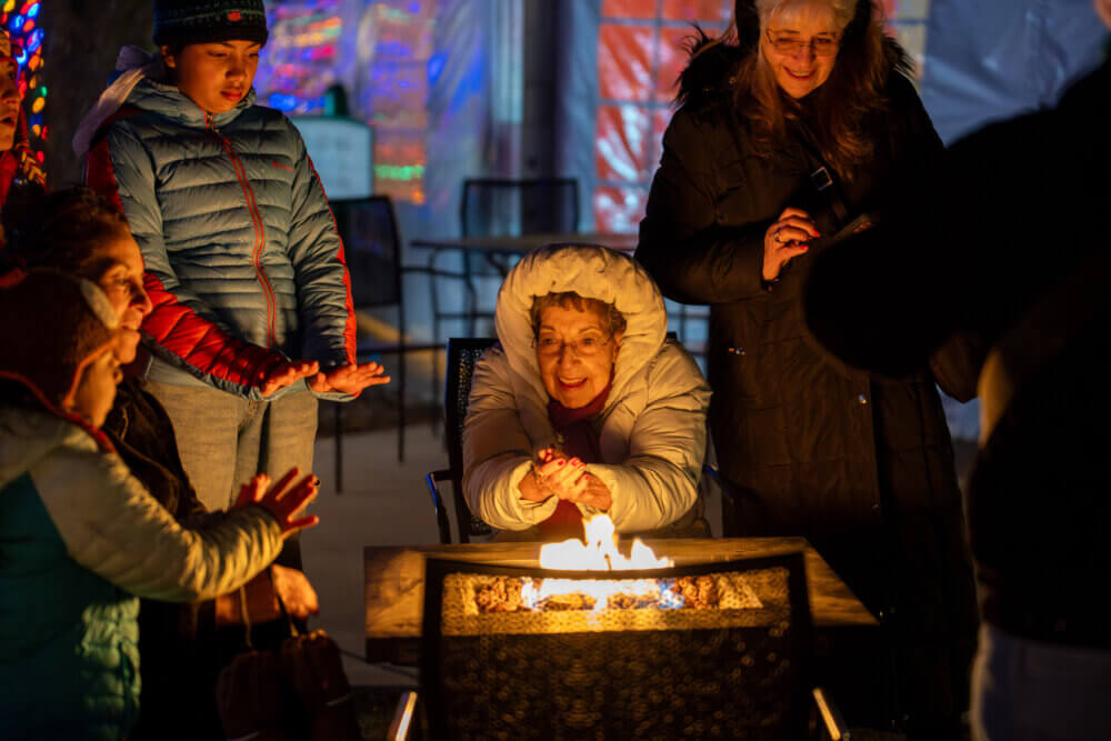 People warming hands over fire pit