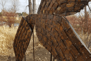 Metal sculpture with lattices and groves that resemble insect wings