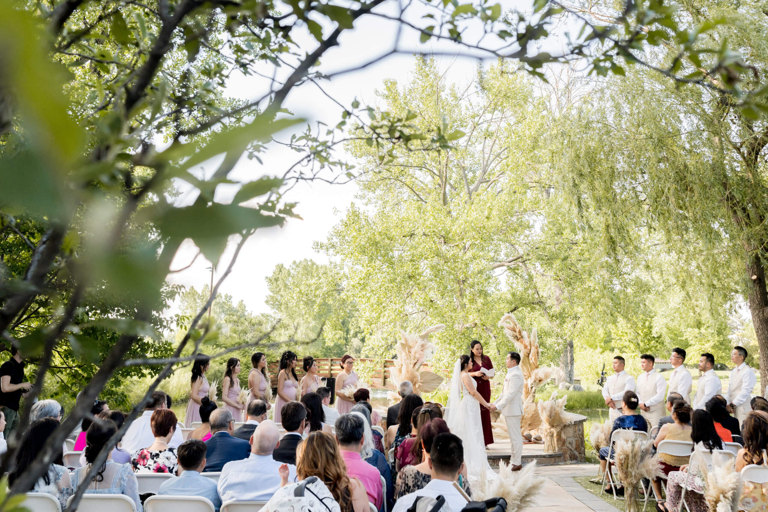 Wedding ceremony at Monet's Place surrounded by green foliage with seated guests